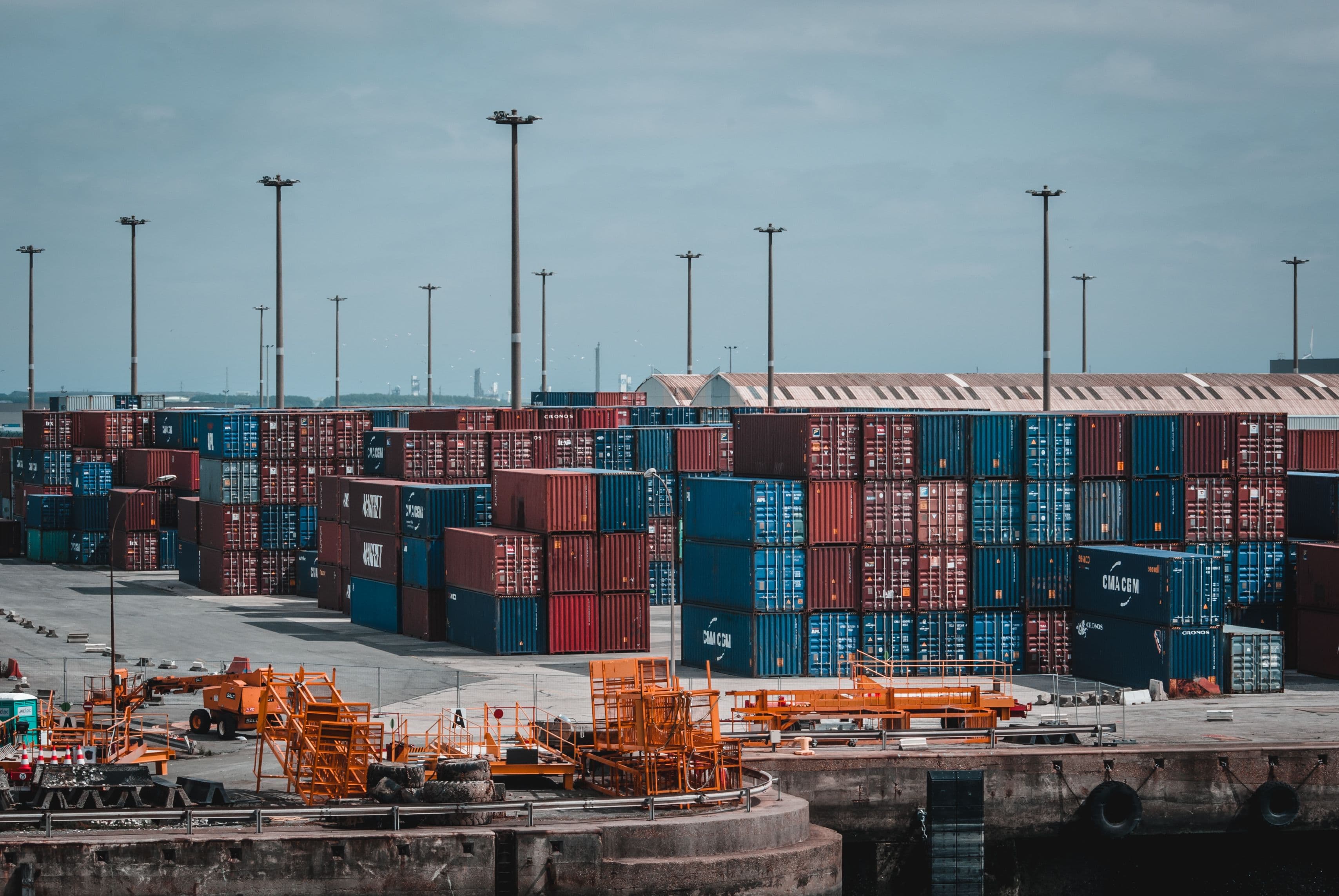 A stack of colorful shipping containers at a port facility